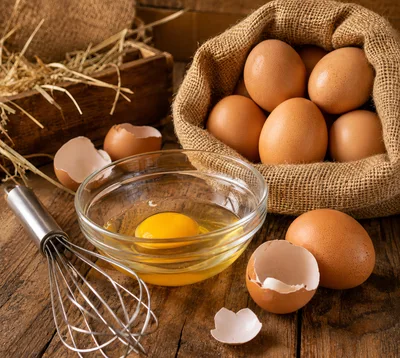 Fresh Brown Eggs in Burlap Sack with Whisk