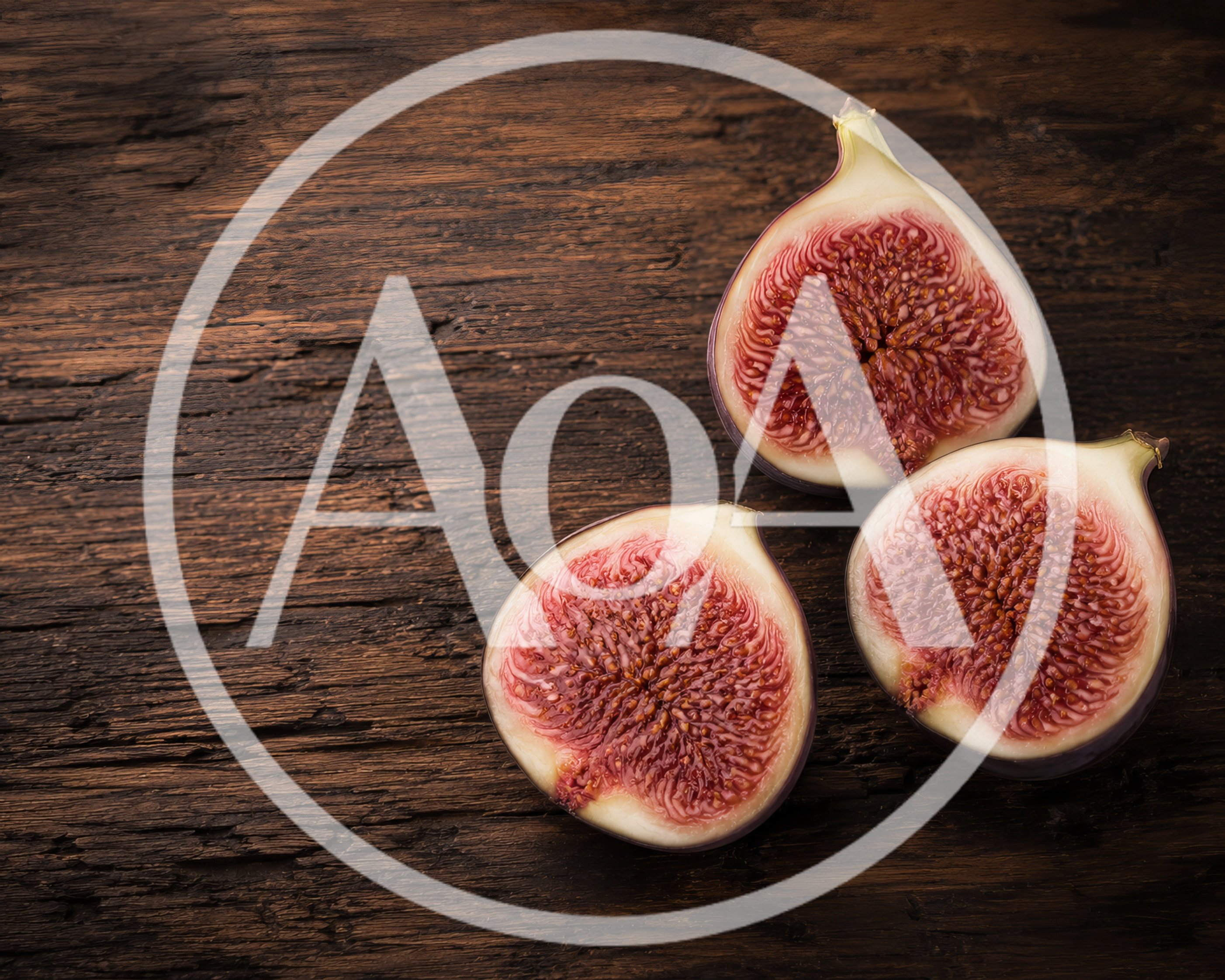 Three Halved Fresh Figs On Rustic Dark Wood