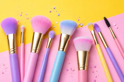 Colorful Makeup Brushes on Yellow and Pink Background