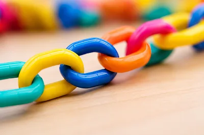 Colorful Plastic Chain Links On Wooden Surface