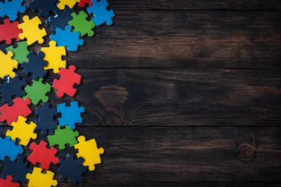 Colorful Jigsaw Puzzle Pieces on Dark Wooden Background