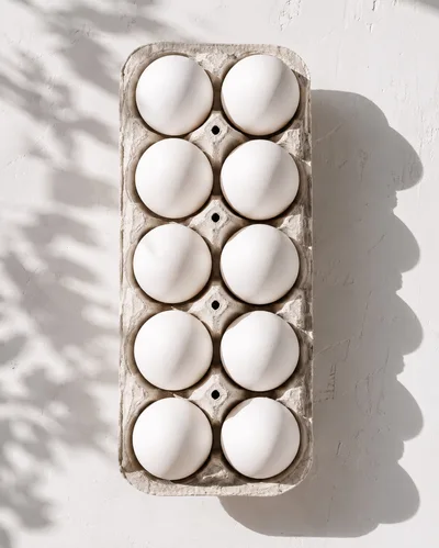 Top View Of Ten White Eggs In Cardboard Carton