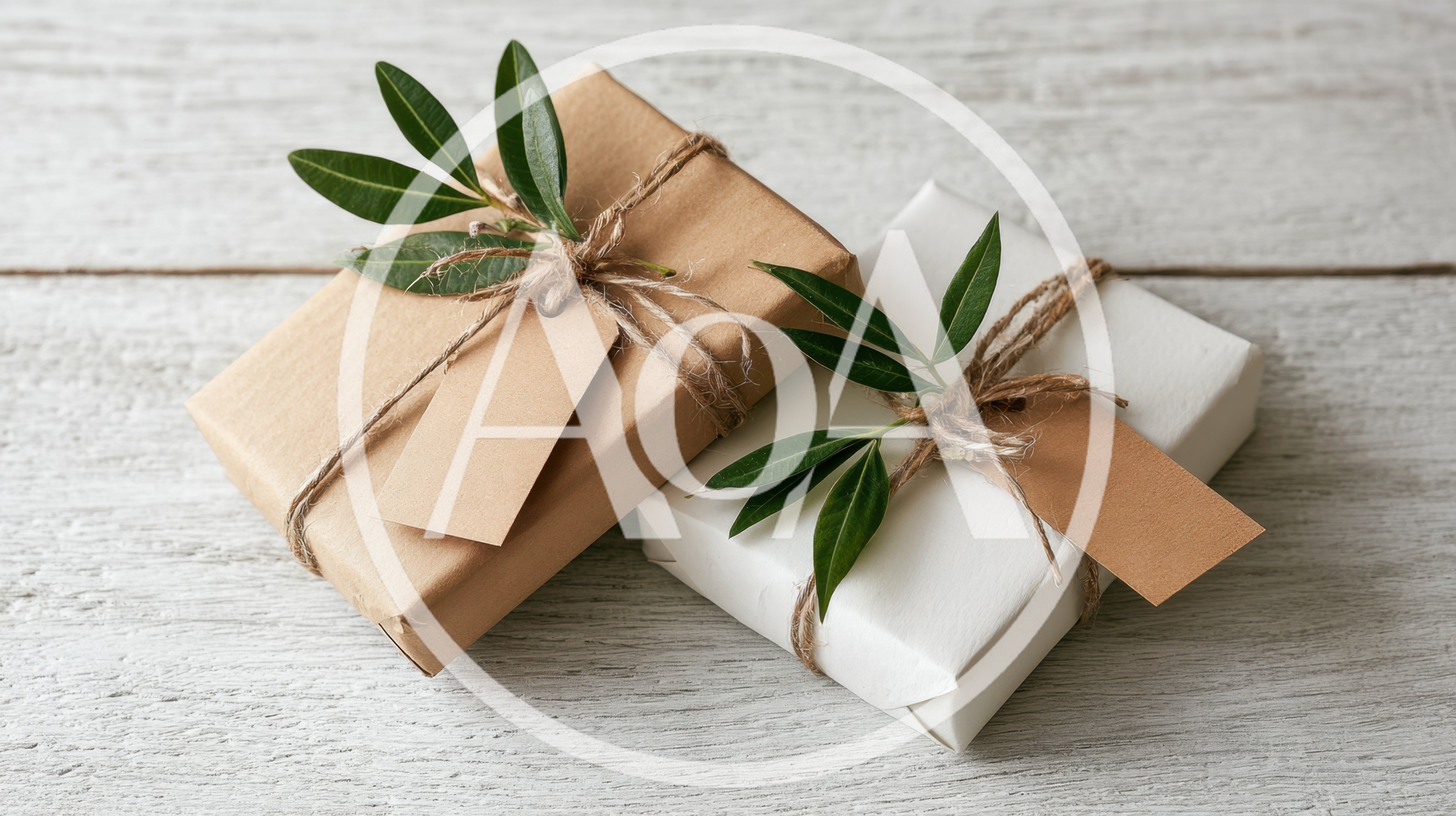 Two Gift Boxes Wrapped In Paper With Green Leaves