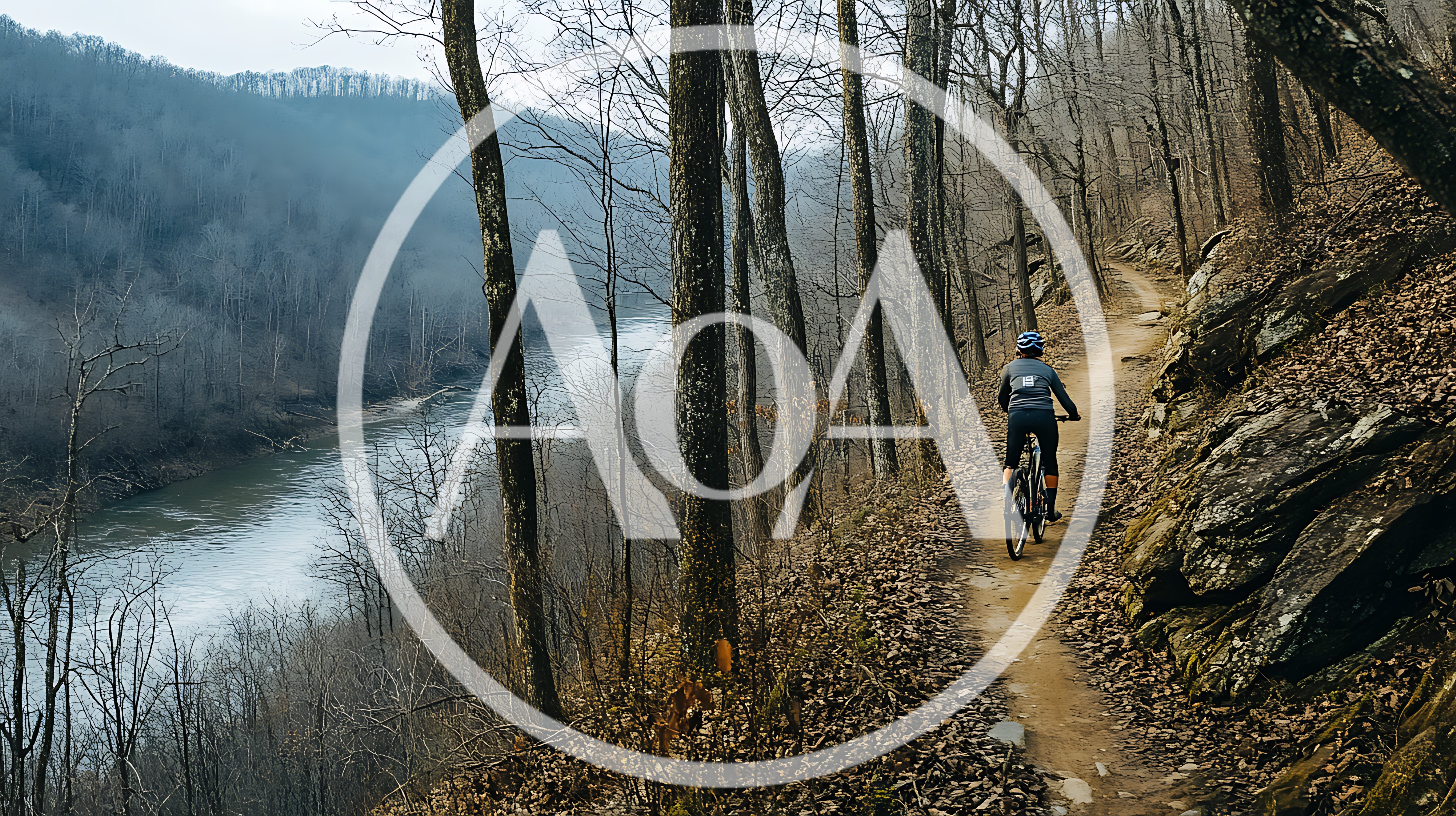 Mountain Biker Riding Along A Scenic River Trail