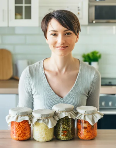 Woman Presenting Homemade Fermented Vegetables In Glass Jars