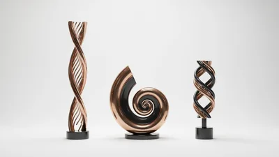 Three Abstract Metallic Sculptures On A White Background