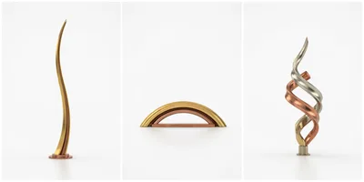 Three Abstract Metallic Sculptures On White Background