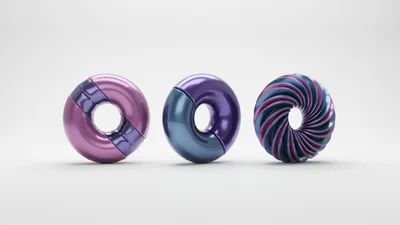 Three Abstract Metallic Torus Shapes On White Background