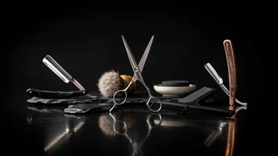 Professional Barber Tools Arranged on Dark Slate Surface