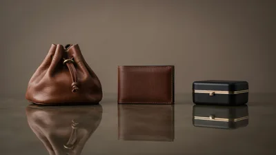 Leather Pouch Wallet and Jewelry Box on Reflective Surface