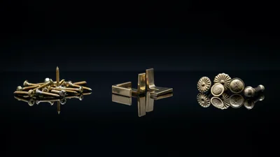 Assorted Brass Hardware Components On Reflective Surface