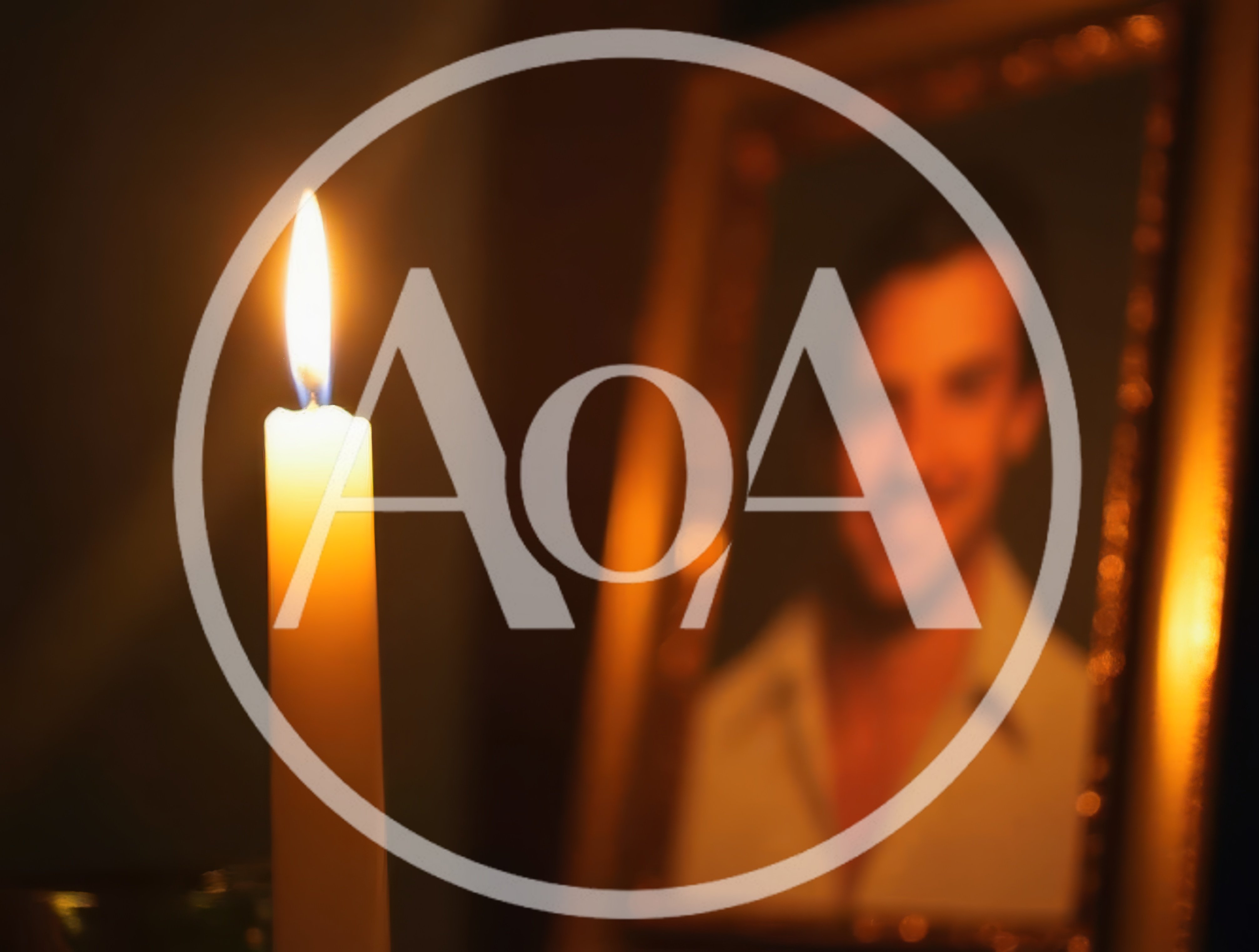 Lit Candle Beside A Framed Portrait Of A Man