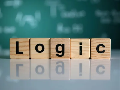 Wooden Blocks Spelling Logic On A Reflective Surface