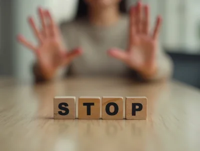 Person Making Stop Gesture Behind Wooden Blocks