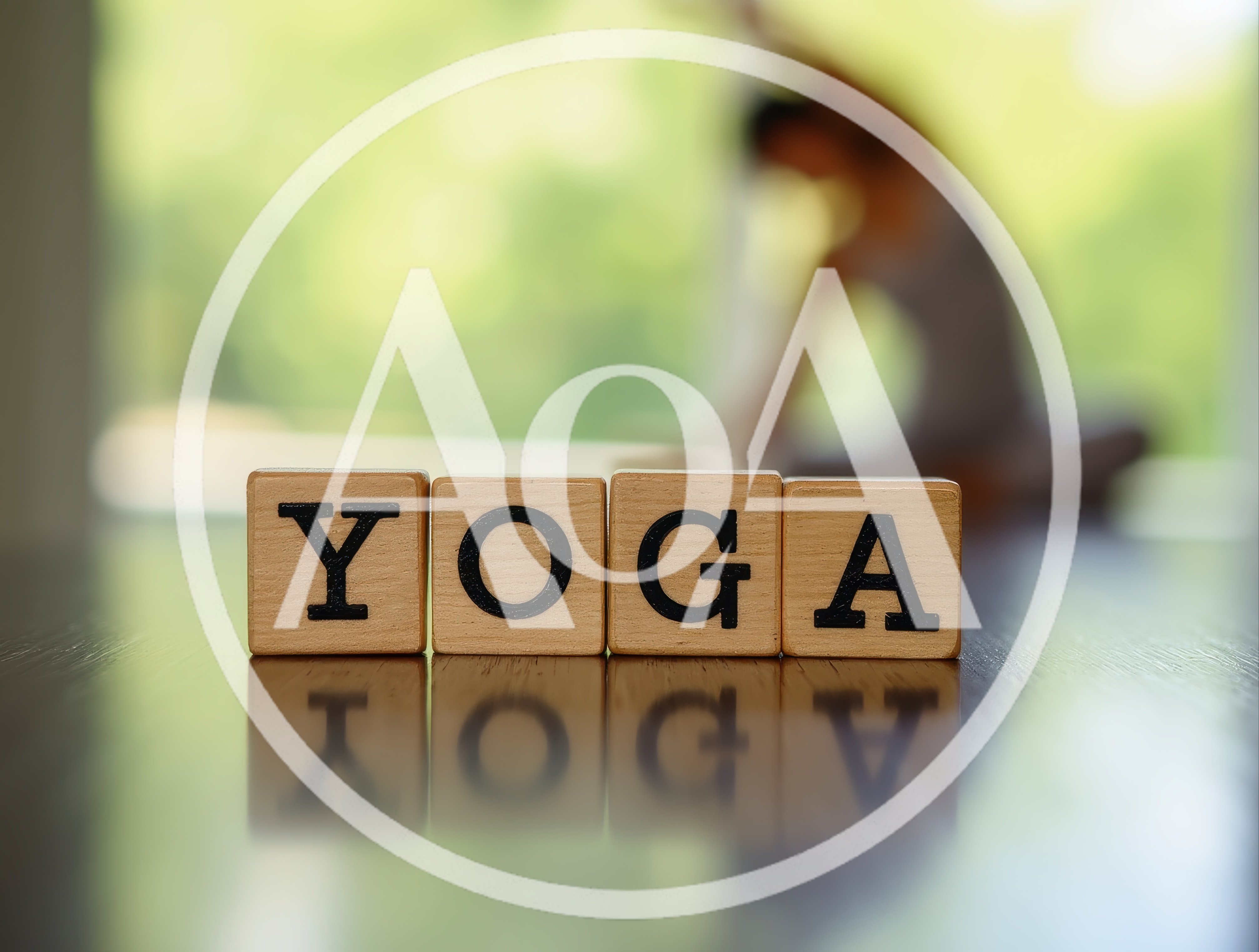 Wooden Blocks Spelling Yoga on a Reflective Surface
