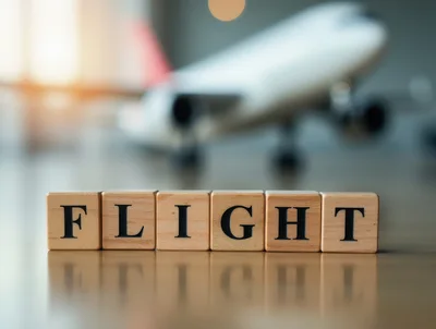 Wooden Blocks Spelling Flight With Blurred Airplane Model