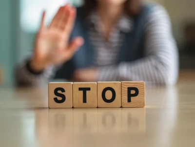 Person Making Stop Gesture Behind Wooden Blocks