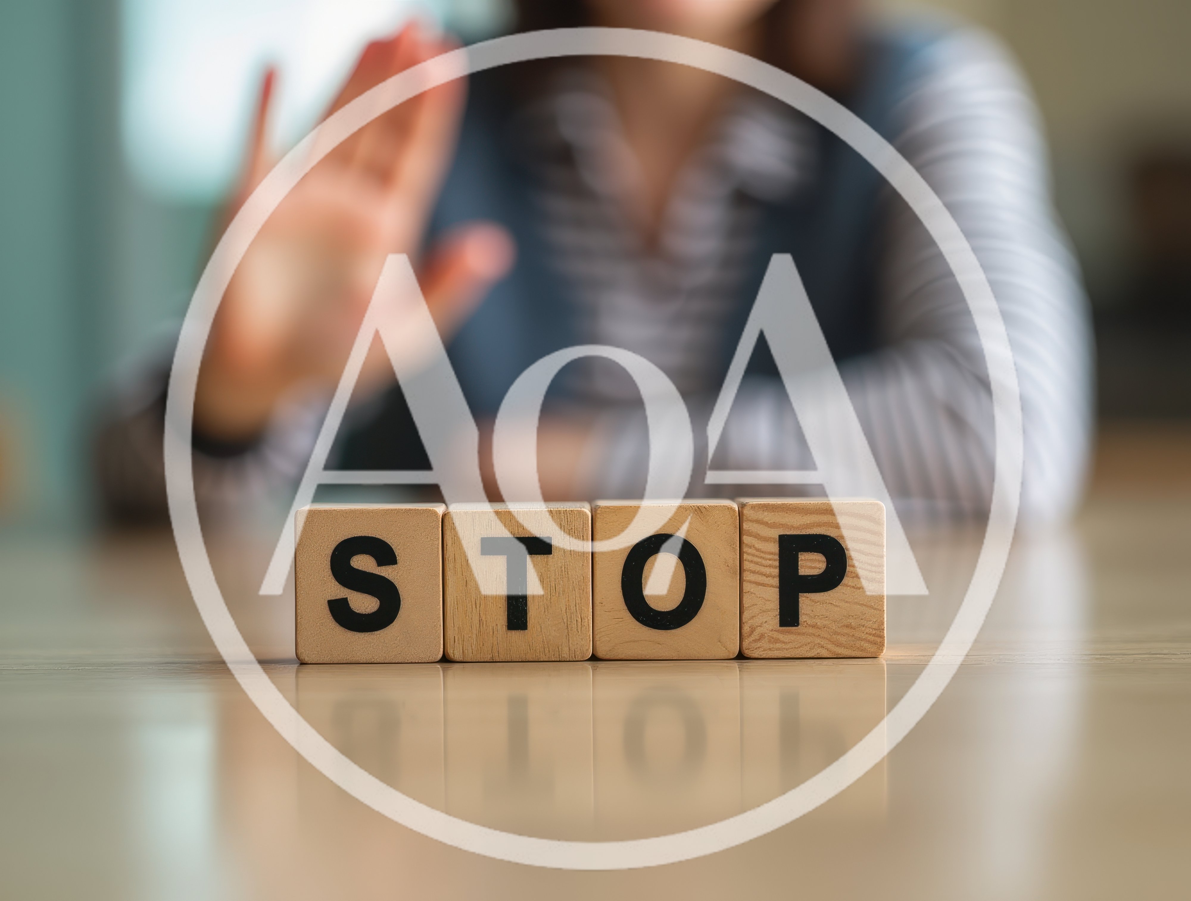 Person Making Stop Gesture Behind Wooden Blocks