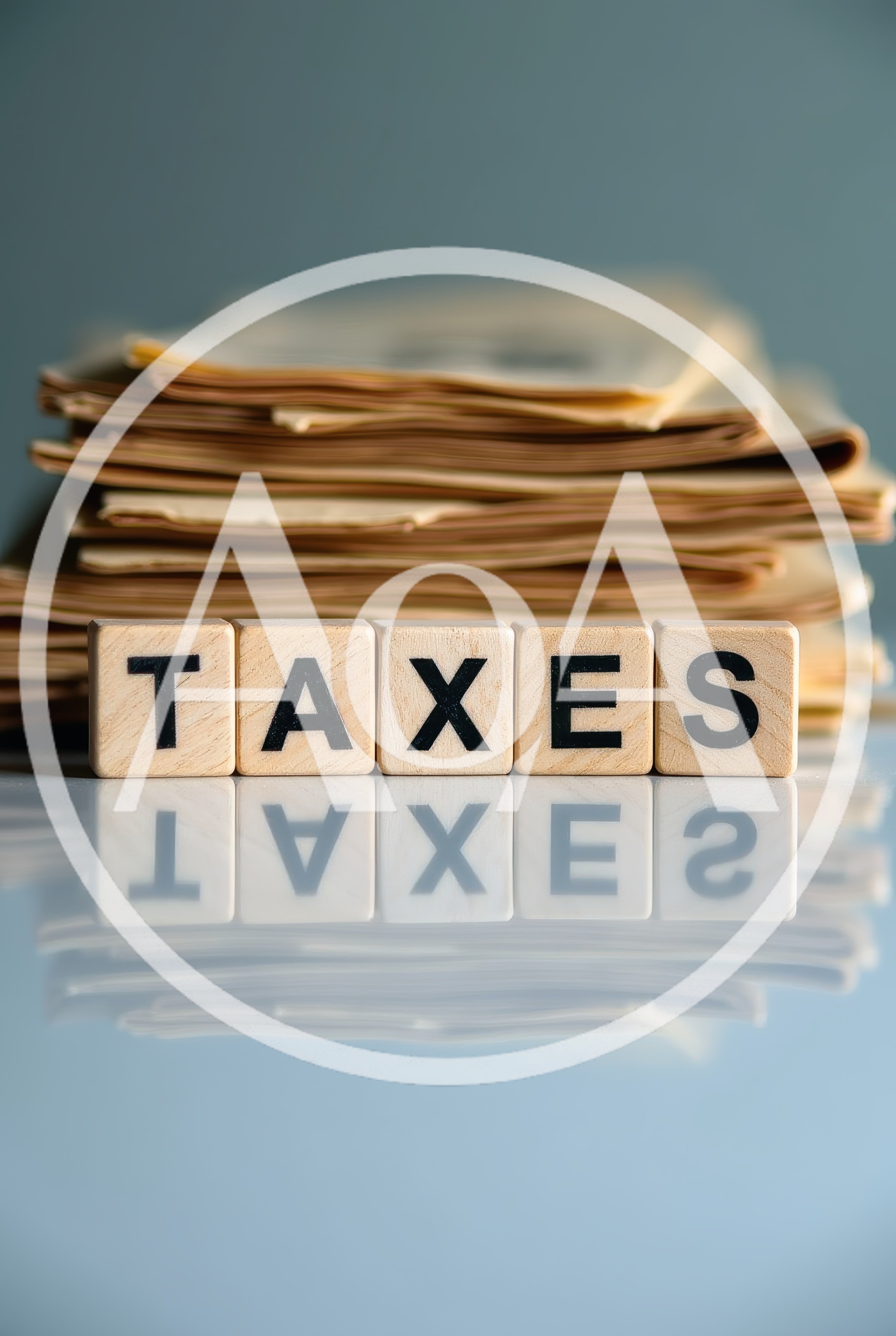 Wooden Letter Tiles Spelling Taxes With Paperwork Stack