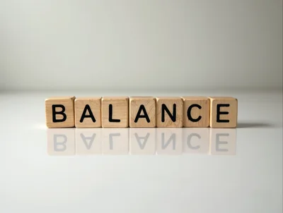 Wooden Blocks Spelling Balance on Reflective Surface