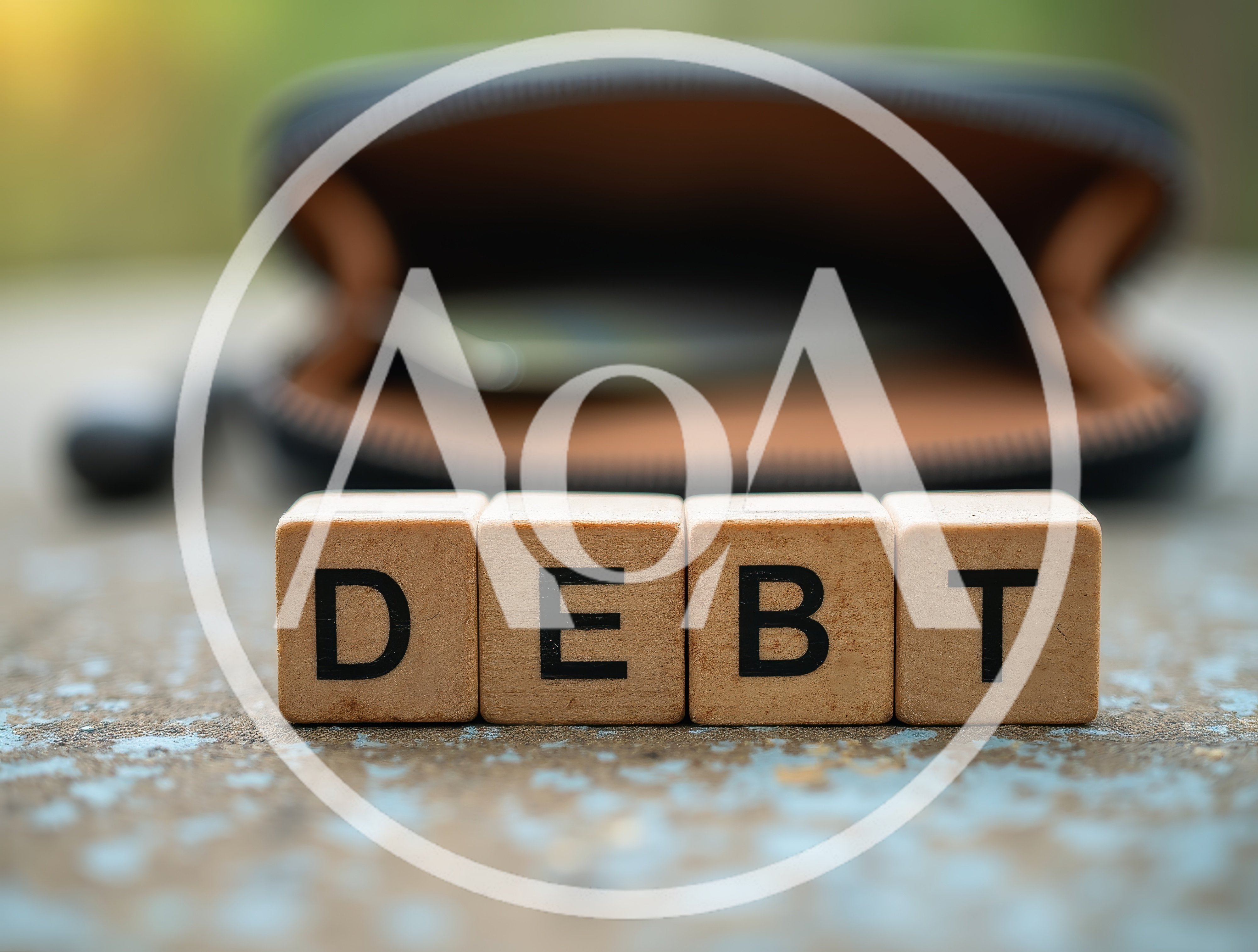 Wooden Blocks Spelling Debt In Front Of An Open Wallet