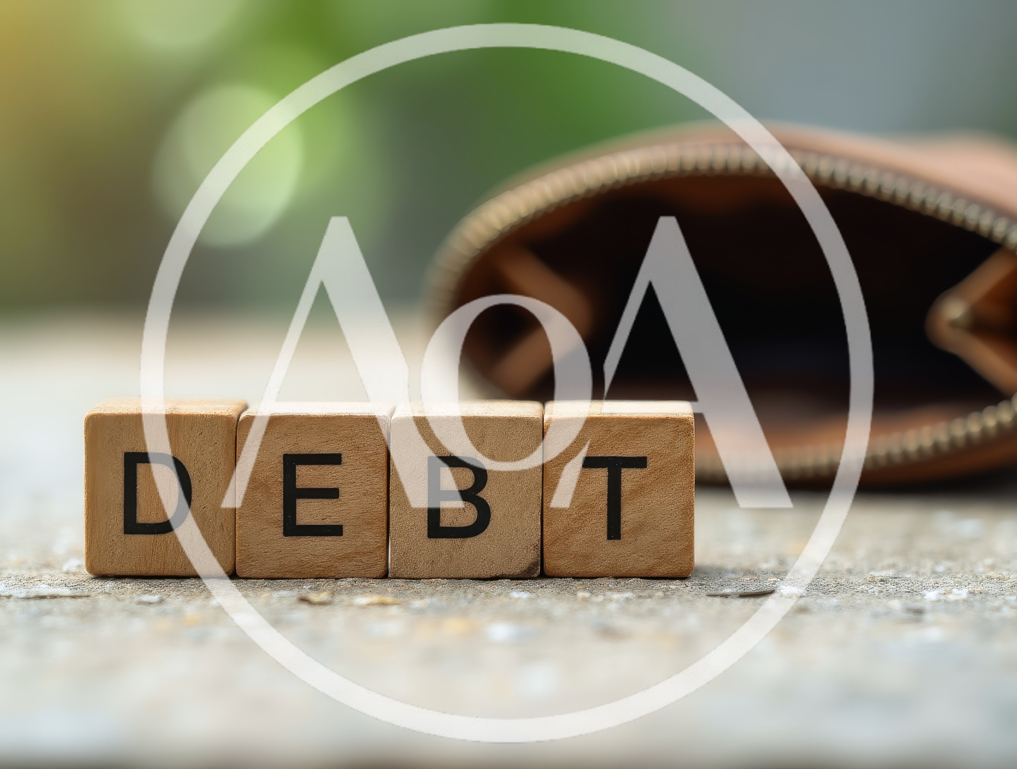 Wooden Blocks Spelling Debt Next To An Empty Wallet