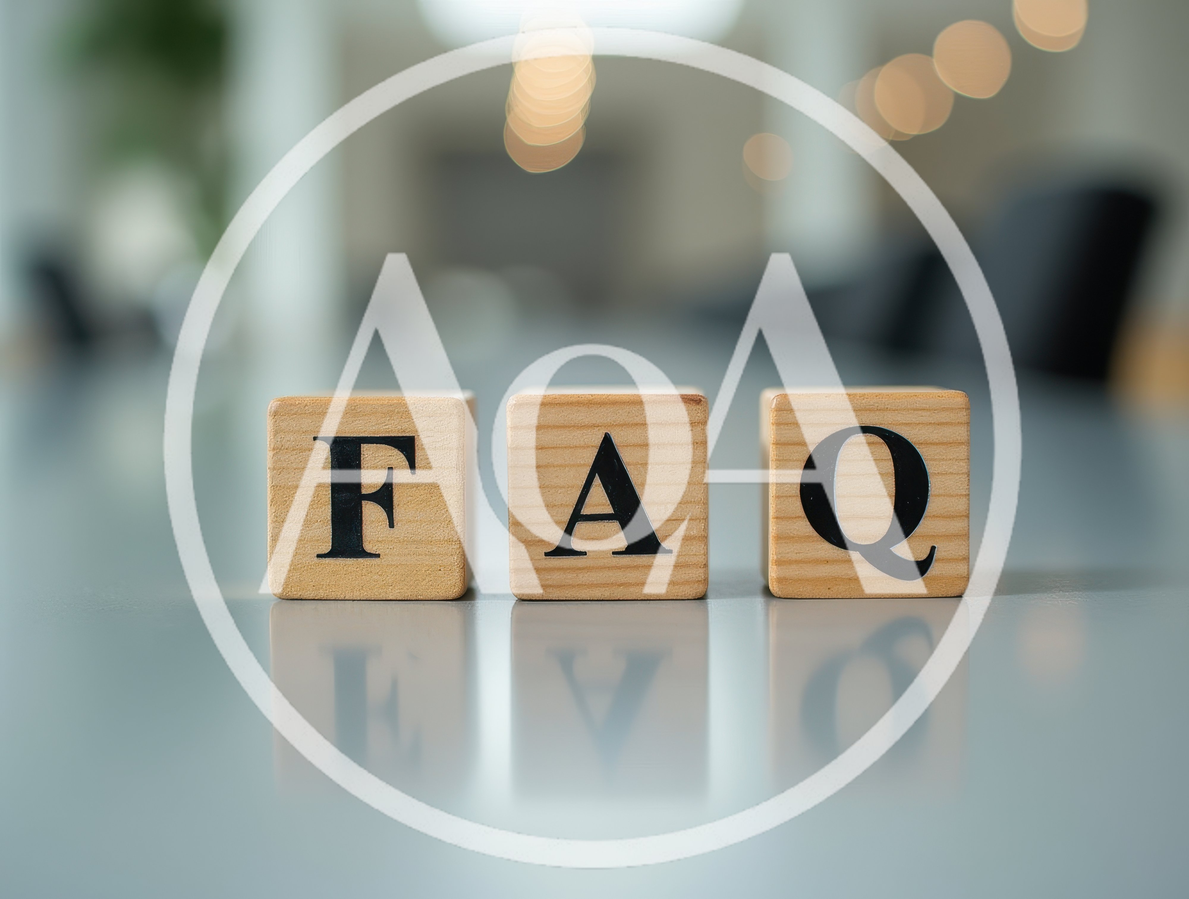 Wooden Blocks Spelling FAQ on a Reflective Table