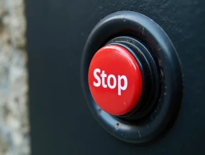 Red Stop Button Mounted On A Dark Wall