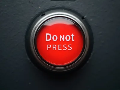 Red Do Not Press Button On Dark Surface