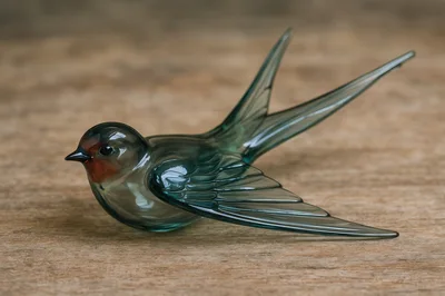 Glass Swallow Figurine On A Wooden Surface