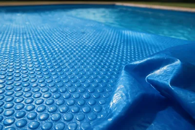 Blue Solar Pool Cover Floating On Water