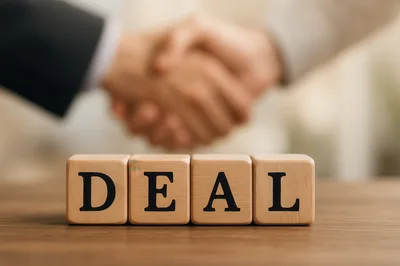 Business Partners Shaking Hands Over Wooden Deal Blocks