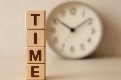 Wooden Blocks Spelling Time With Blurred Clock Background