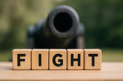 Wooden Blocks Spelling Fight In Front Of A Cannon