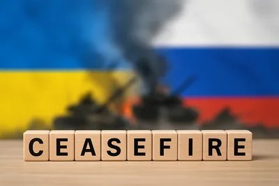 Wooden Blocks Spelling Ceasefire Against Blurred War Background
