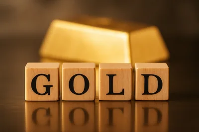 Wooden Blocks Spelling Gold With A Gold Bar