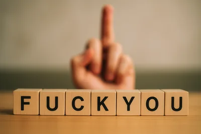 Wooden Blocks Spelling Fuck You With Middle Finger Gesture