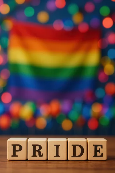 Wooden Blocks Spelling Pride With Rainbow Flag Background