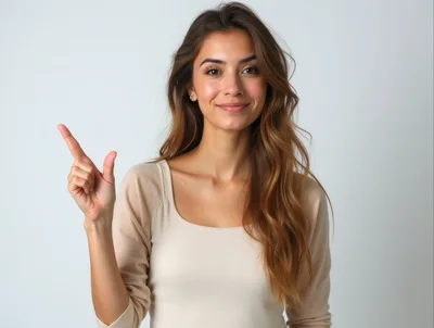 Young Woman Pointing Upwards Against A Plain Background