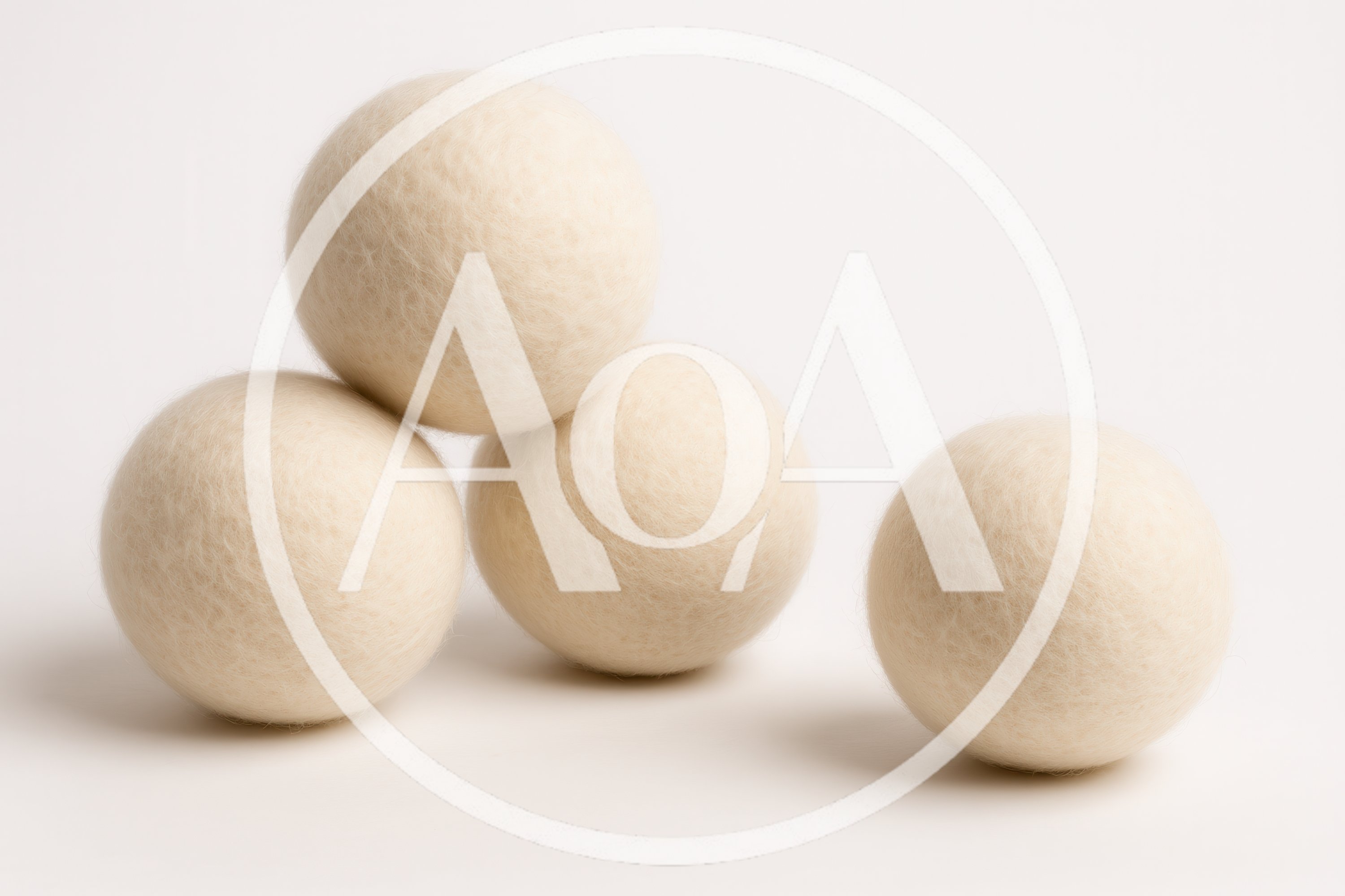 Four White Wool Dryer Balls On White Background