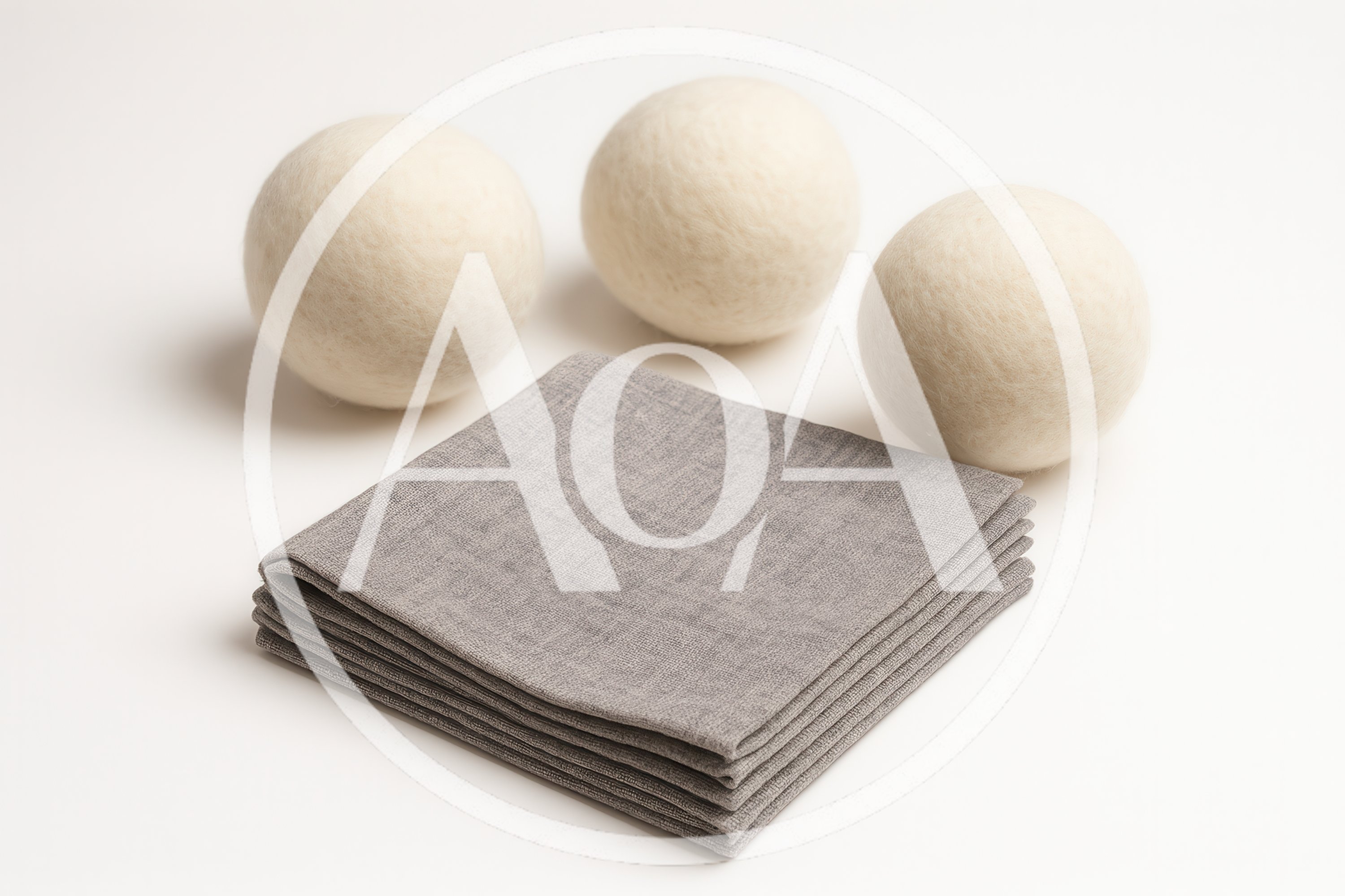 Three Wool Dryer Balls With Folded Grey Fabric Napkins
