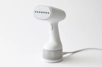 White Handheld Garment Steamer On Plain Background