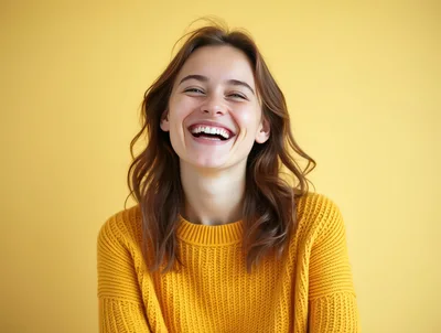 Happy Young Woman Laughing Against Yellow Background