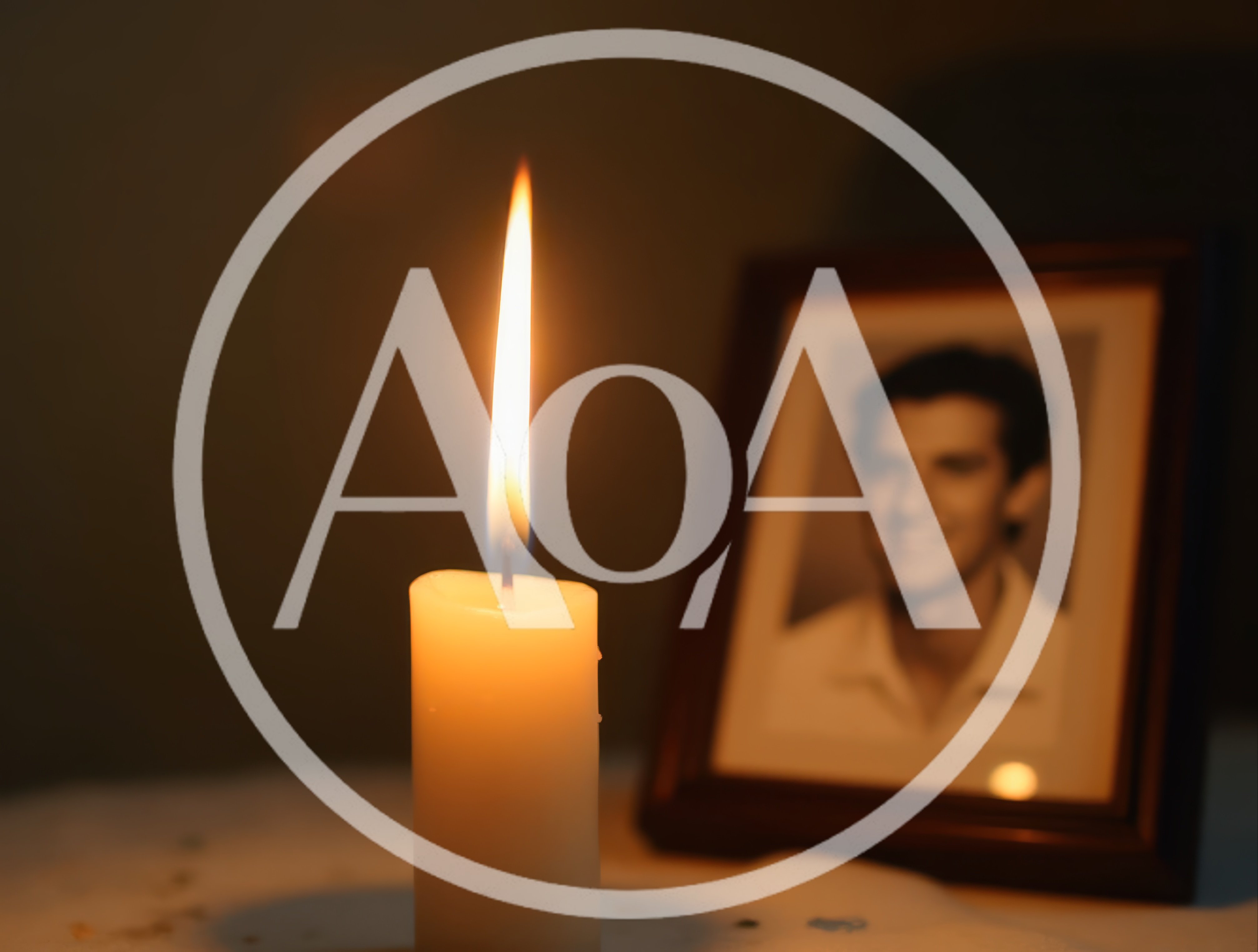 Lit Candle Beside A Framed Portrait Of A Man