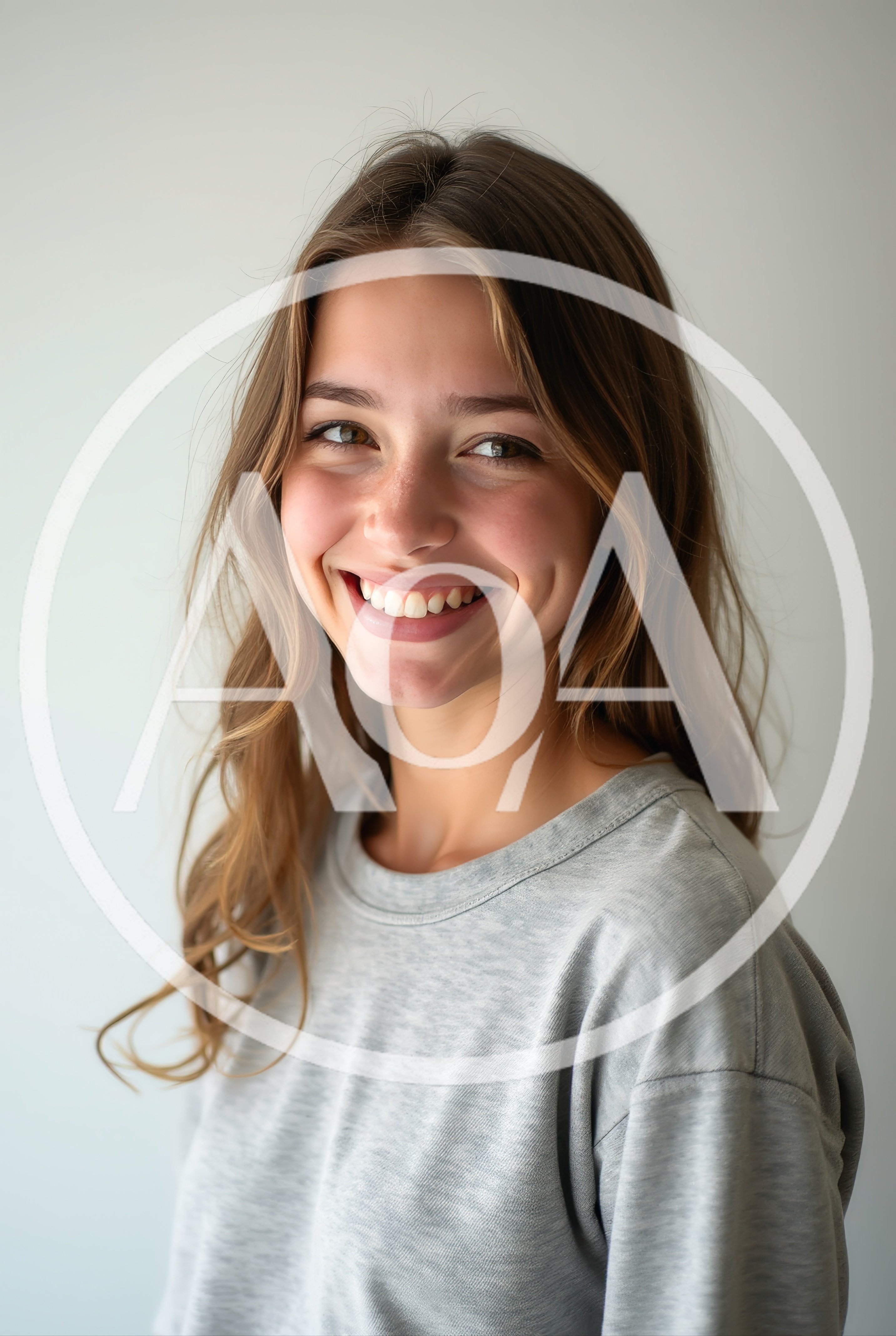Portrait Of A Smiling Young Woman In Grey Shirt