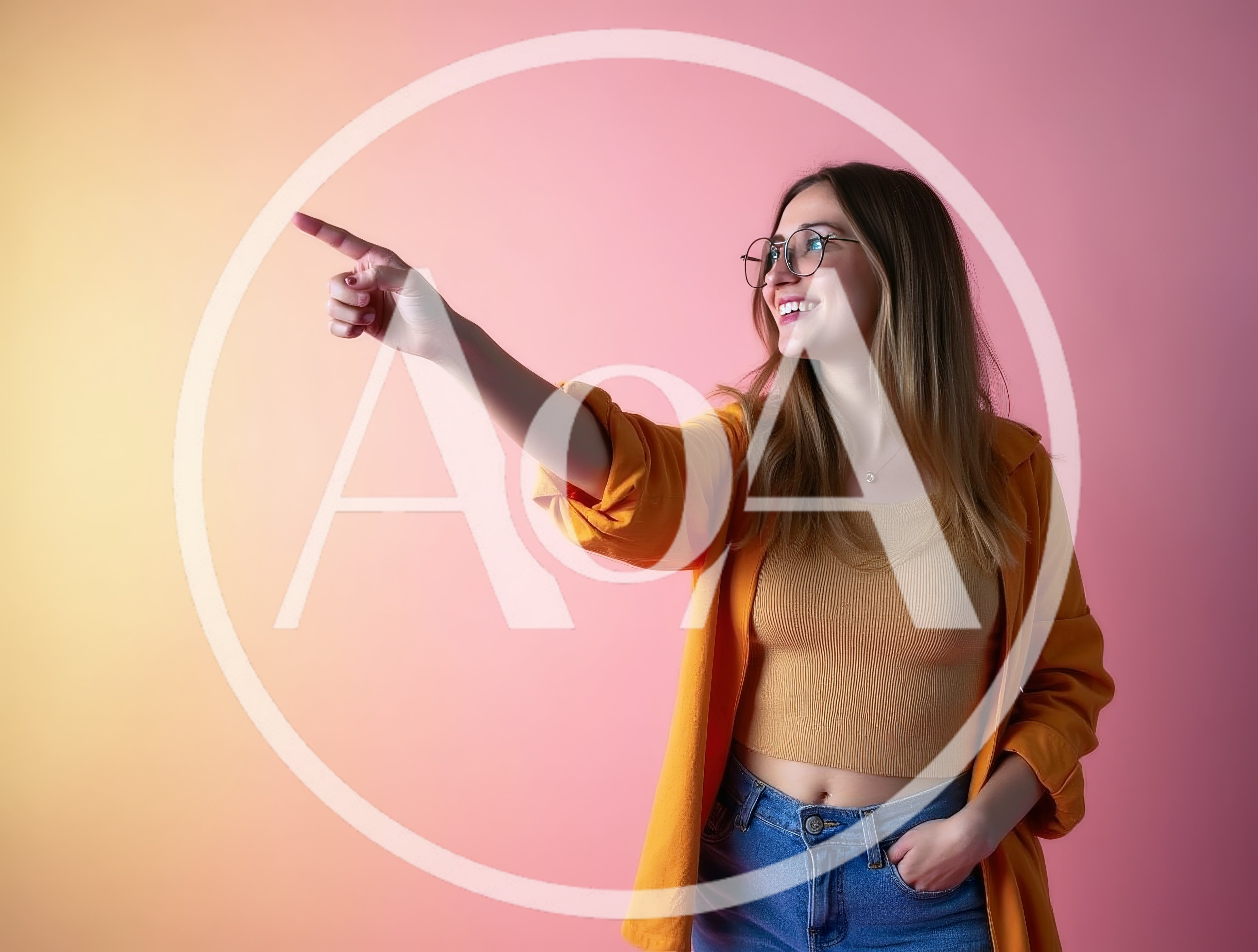 Young Woman Pointing To The Side Against Pink Background