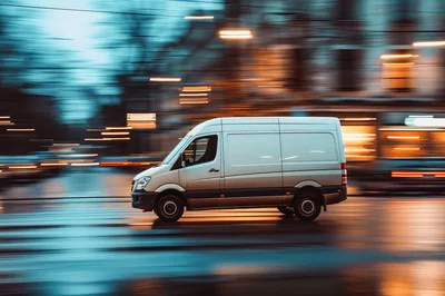 White Delivery Van Driving Through City Street
