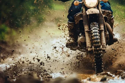 Dirt Bike Rider Splashing Through Muddy Trail