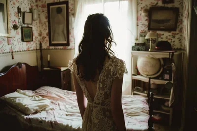 Bride Standing In Bedroom Before Wedding Ceremony