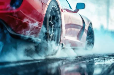 Red Sports Car Performing A Burnout On Wet Asphalt